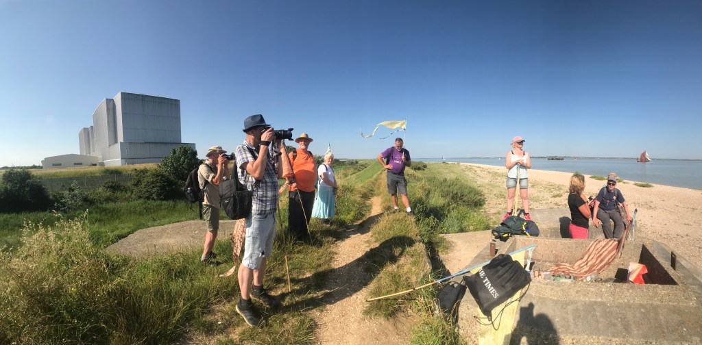 Photograph of the walkers paused by the entombed Bradwell Nuclear Power Station to hear Angenita Teekens speak.